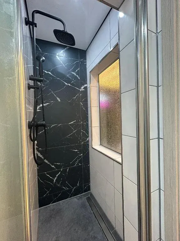 Regendusche mit schwarzen Marmorfliesen